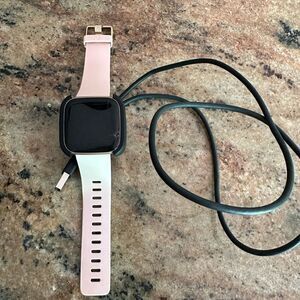 Fitbit versa with pink band and charger